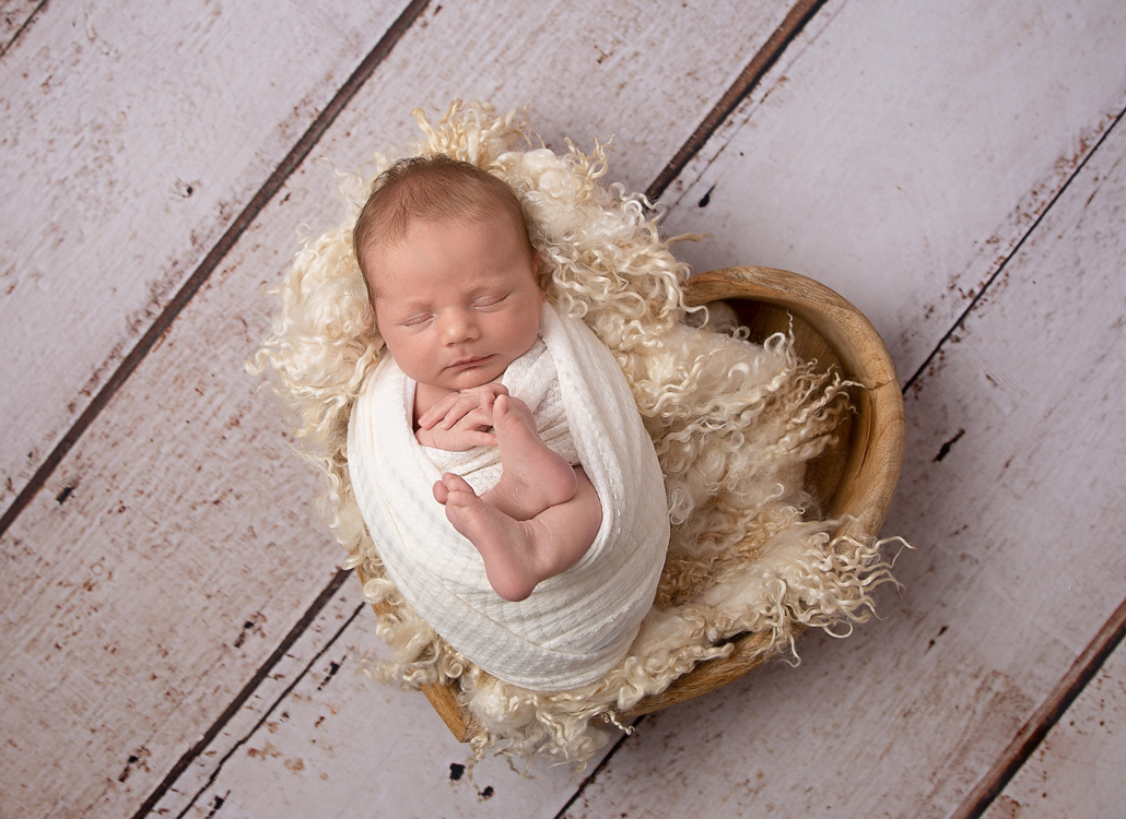 newborn photography ipswich baby in heart bowl with white fur newborn photography ipswich baby in heart bowl with white fur